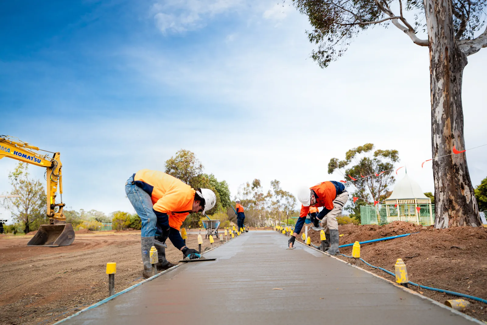 Crew finishing a concrete path pour
